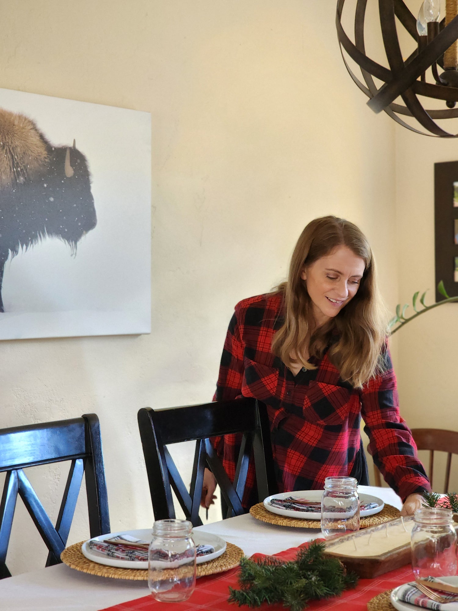 Setting the table for a holiday gathering. The table is set with festive red runner and soft plaid flannel napkins.