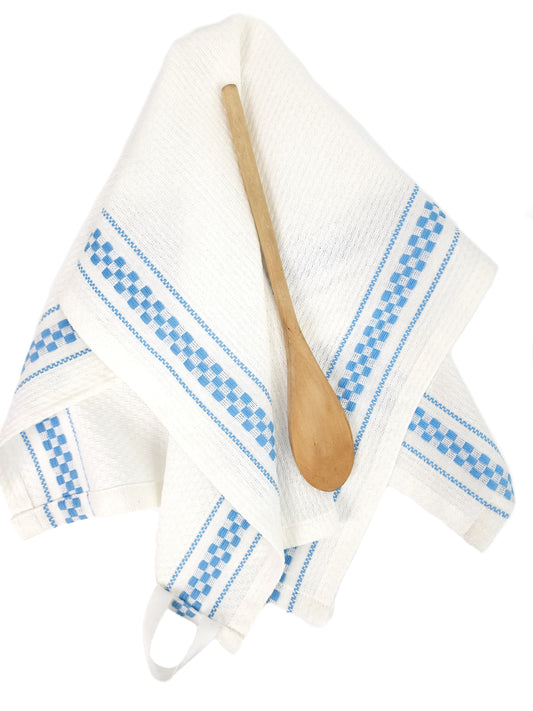 White towel with blue patterns and a wooden spoon on a white background