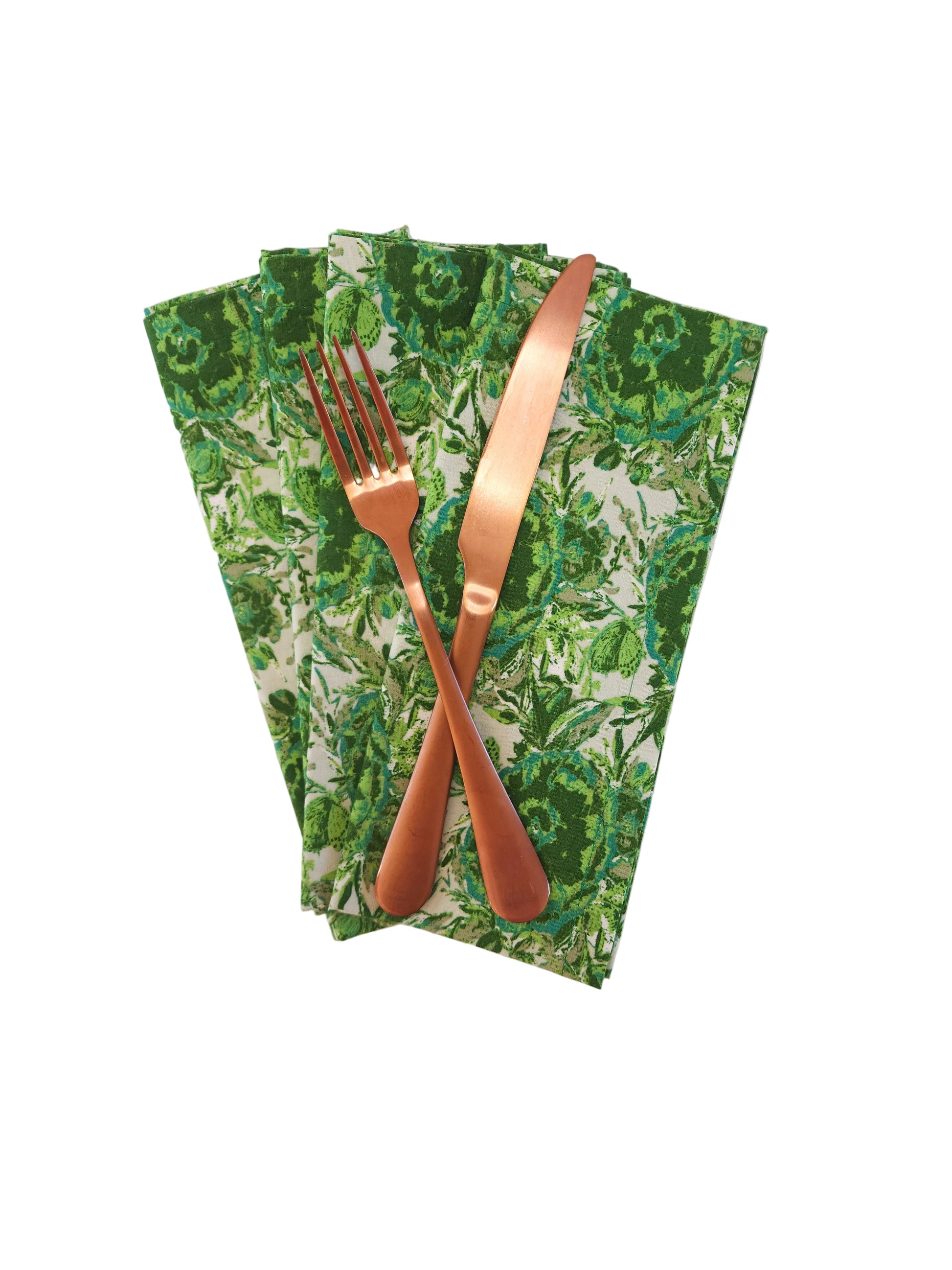 Green leaf-patterned napkin with a copper fork and knife on a white background