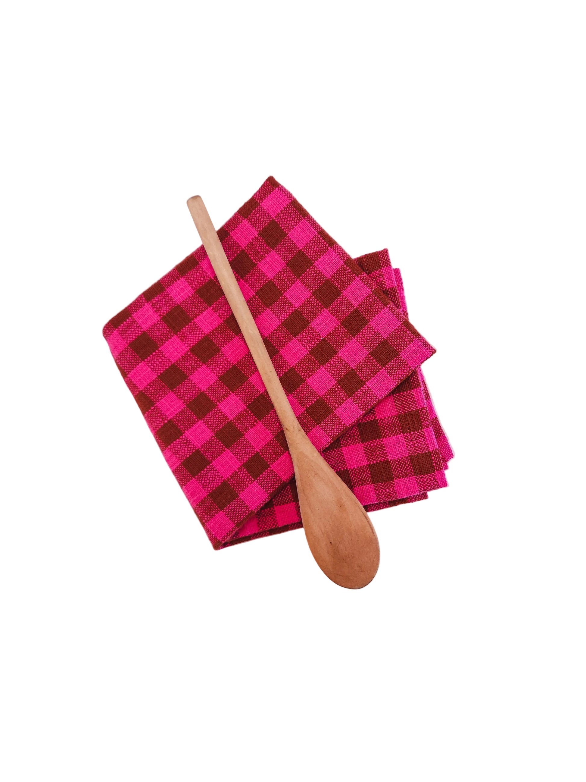 Pink and brown checkered towel folded with a wooden spoon on a white background