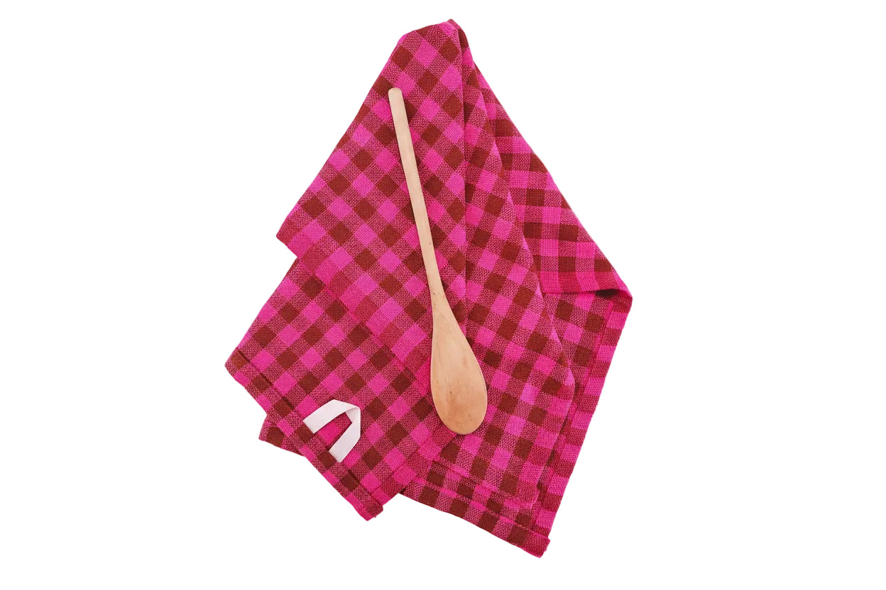 Pink checkered towel with a wooden spoon on a white background