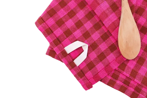 Close-up of a cotton hanging loop on a pink and brown checkered towel.