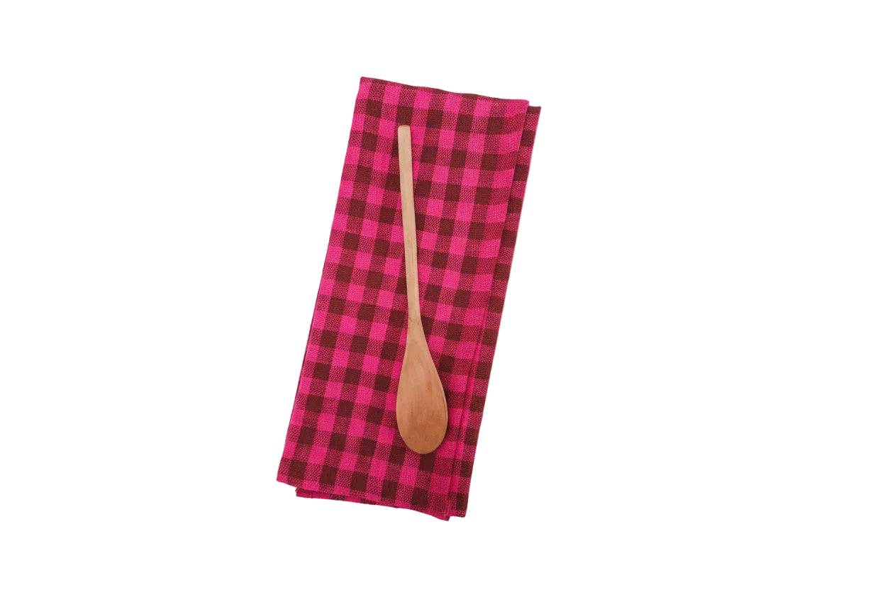Pink and brown checkered towel with a wooden spoon on a white background
