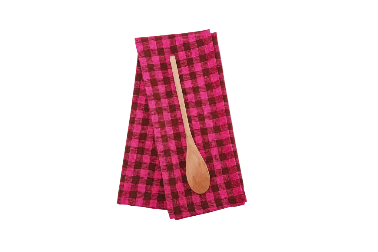 Pink and brown checkered towel with a wooden spoon on a white background