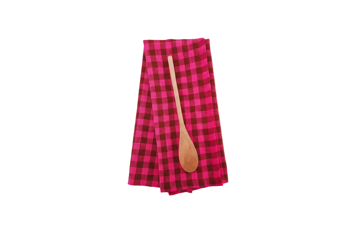 Pink and brown plaid towel with a wooden spoon on a white background