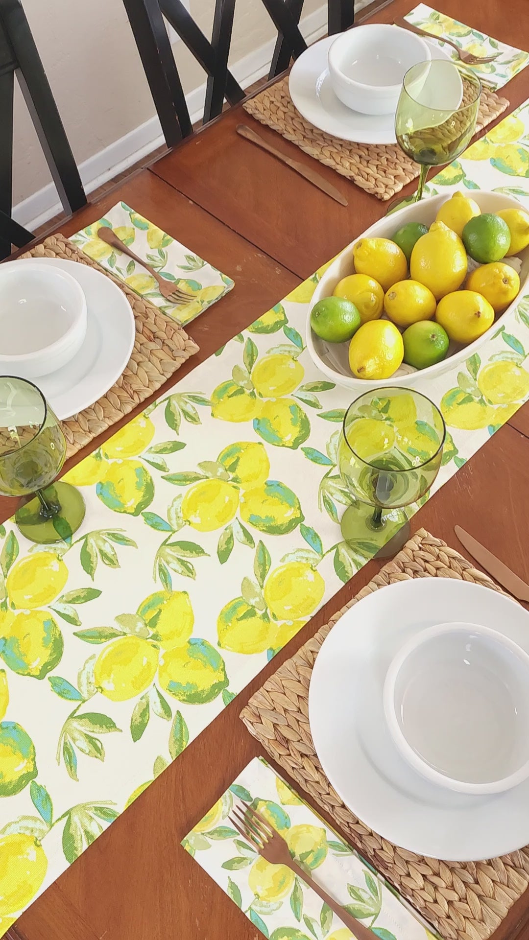 Video of a table set with a citrus theme including a table runner and matching napkins with a vibrant lemon print.